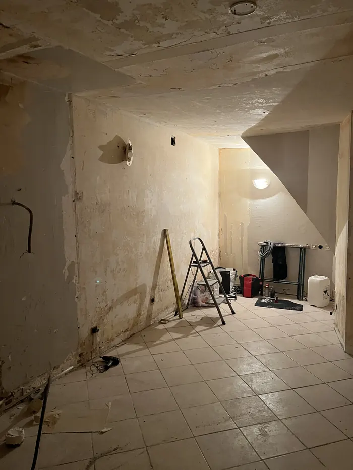Chambre avant travaux de peinture : anciens revêtements déposés, murs et plafond abîmés