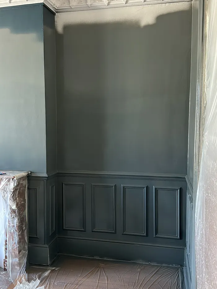 Mise en peinture bleu nuit d'un salon haussmannien avec soubassement à moulures